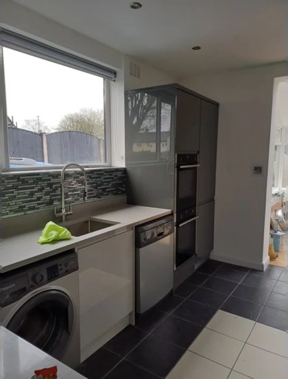 A kitchen run with the sink under the window and the appliances in