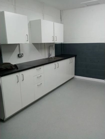 A kitchenette fitted in a commercial unit, with a solid worktop