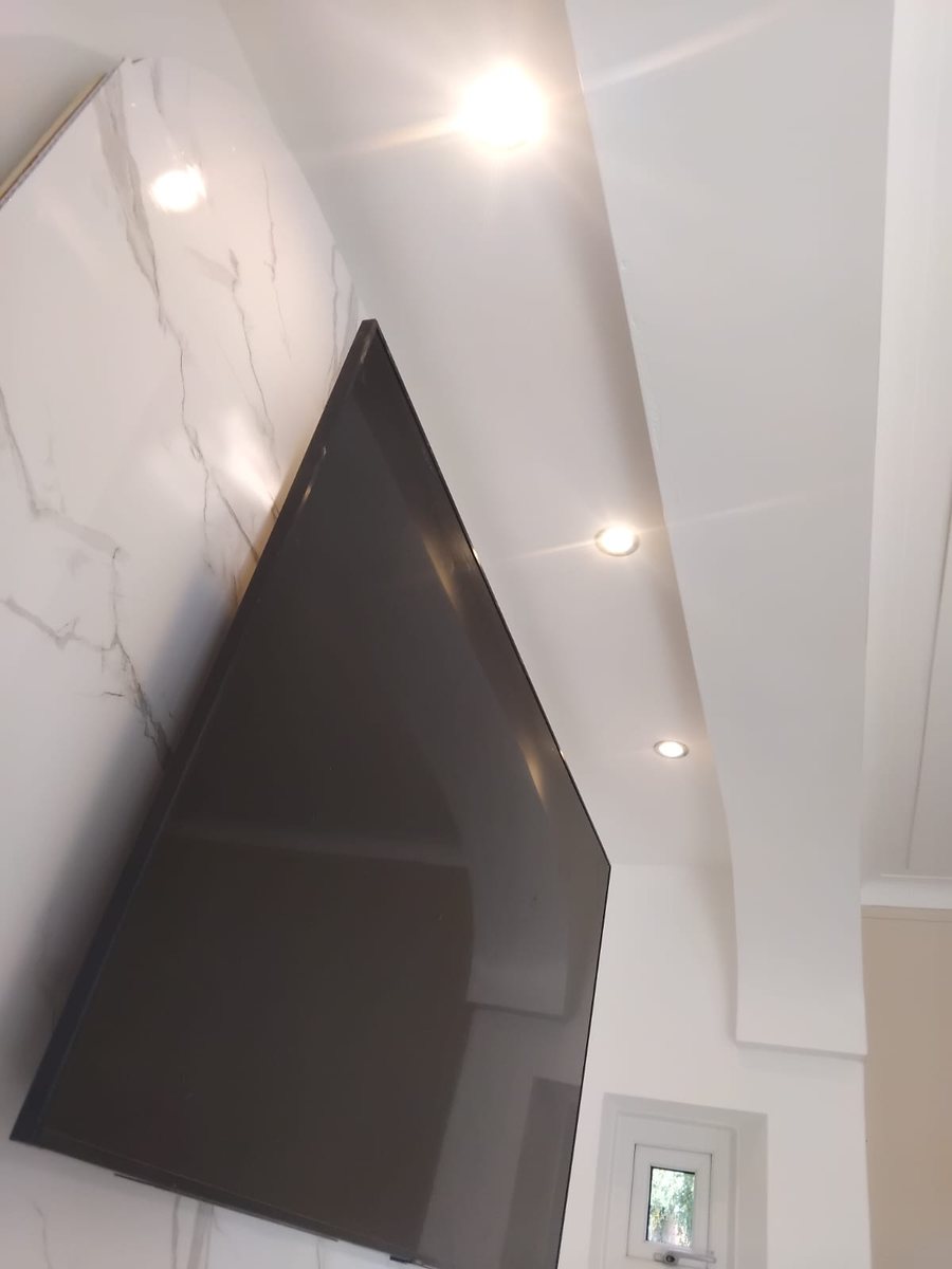The media wall close up: the marble effect panel and the curved bulkhead with its spotlights